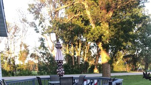 Een terras met buitenmeubilair, een barbecue en een vlag.