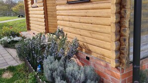 Una cabaña de madera con dos ventanas y cimientos de ladrillo.