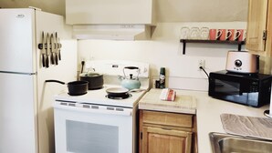 A compact kitchen with a white stove, a microwave, and a small sink. - Soleil Salem- extended stays, free laundry, garden (Salem)