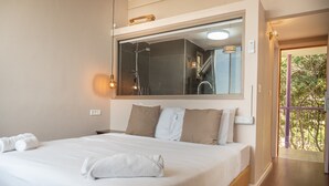 A bedroom with a large bed, a mirror above the bed, and a view of a balcony. - Mantur Metula by Selina (Metula)