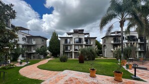 Une cour intérieure dotée d’une allée pavée, entourée d’immeubles à plusieurs étages, avec des balcons et des façades en pierre.