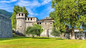 A historic stone building with a tower, surrounded by well-maintained grass and trees. - ICON H Lugano 204 Suite Micro-Living, Lugano, Switzerland (Lugano)