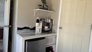 A compact kitchenette with a microwave, coffee maker, and a small refrigerator.