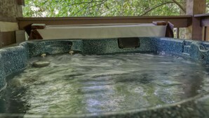 A hot tub with a wooden deck and a view of trees. - Beautiful Authentic Log Cabin on Cosby Creek (Cosby)