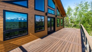 Un bâtiment moderne en bois, doté de grandes fenêtres et d’une terrasse.