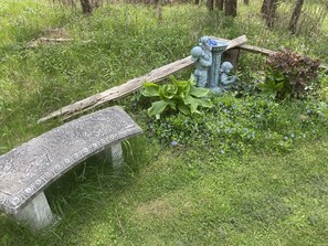 Sit and unwind in a serene garden setting with a beautifully carved stone bench and a soothing fountain.