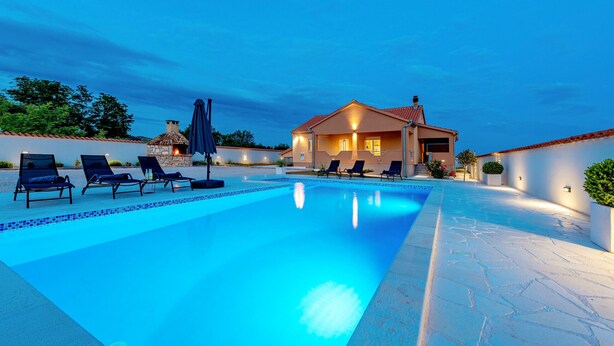 A swimming pool with lounge chairs and a house in the background. - Villa Jenny (Policnik)