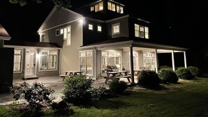 A two-story house with a covered patio area, a front door, and a visible staircase leading to the upper level.