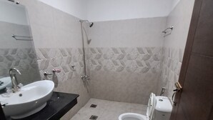 Ein Badezimmer mit Waschbecken, Toilette, Dusche und Spiegel.