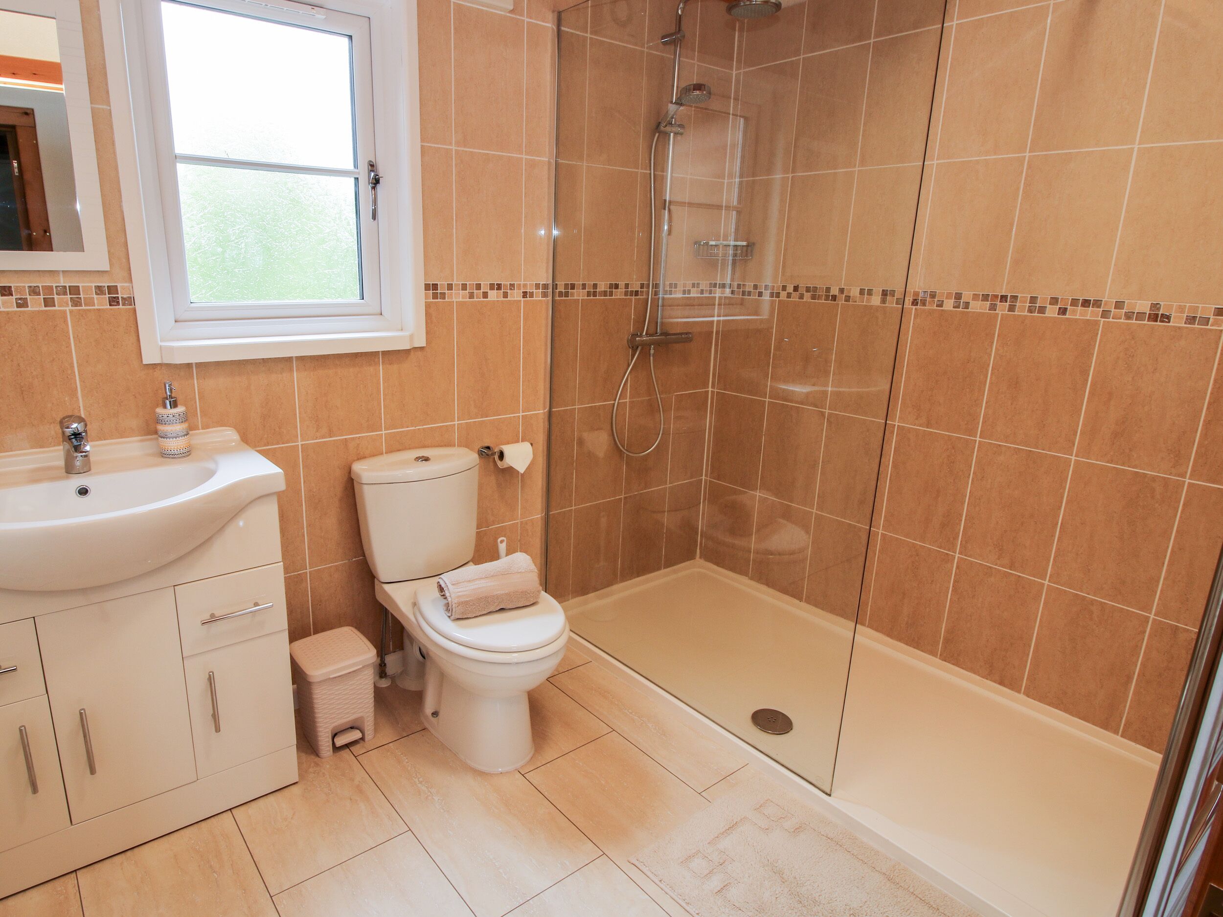 Un baño con lavamanos, inodoro y ducha.