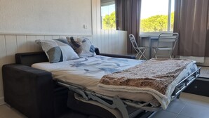 Une chambre moderne comprenant un lit, un canapé, une table à manger et une chaise.