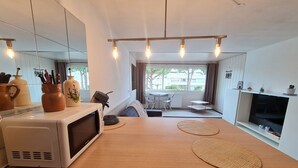 Une cuisine moderne équipée d’un four à micro-ondes, d’un comptoir en bois et de sets de table en fibres tressées.