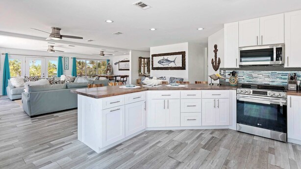 A modern kitchen with white cabinetry, a central island, and an LG oven.