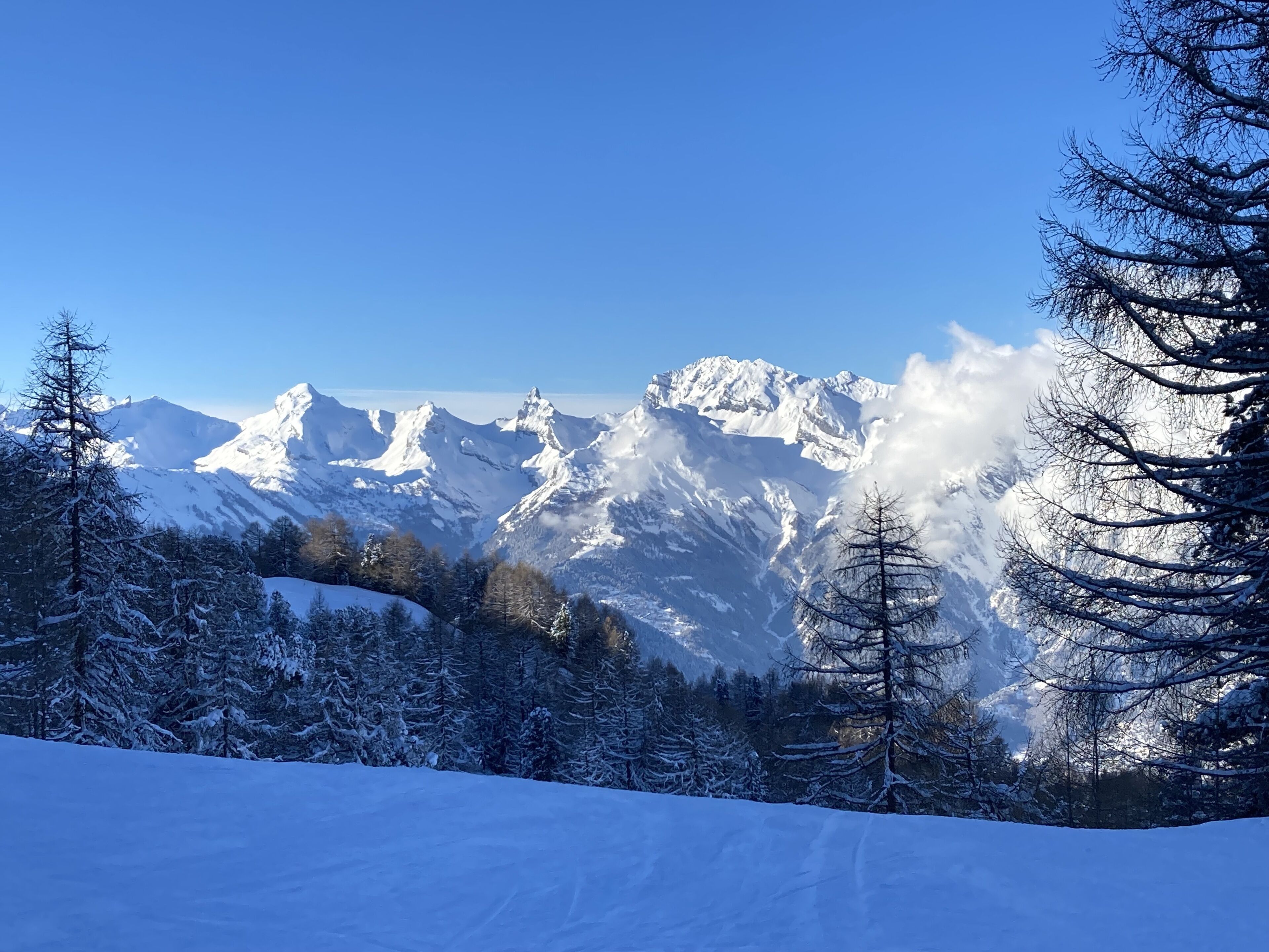 Un paysage de montagne enneigé, sous un ciel dégagé.
