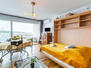 Een moderne slaapkamer met een bed, een eettafel en een balkon met uitzicht.