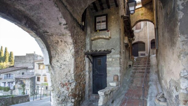 An old stone building with a staircase leading to an upper level.