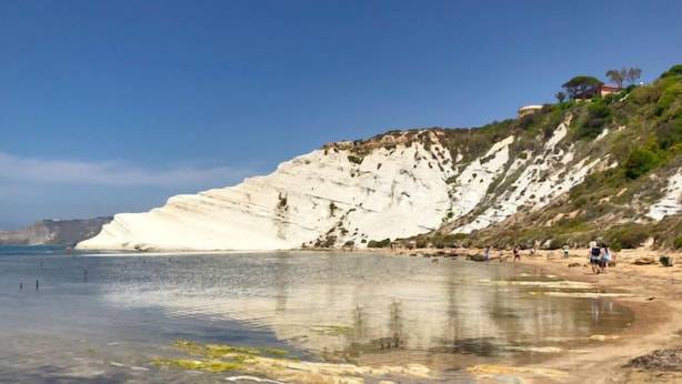 Une plage bordée de falaises blanches, avec une eau cristalline et peu de monde.