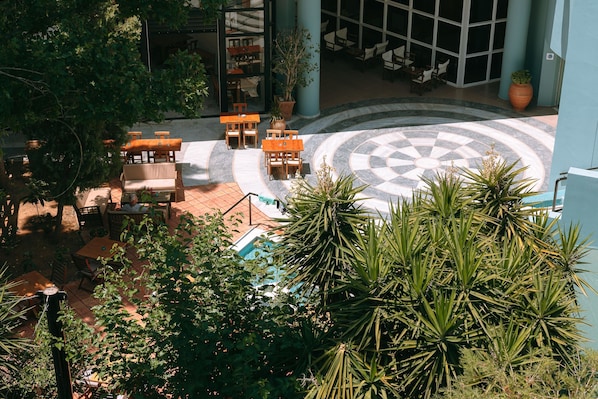 A courtyard with outdoor seating, a pool, and potted plants.