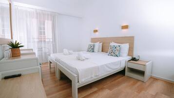 Un dormitorio moderno con cama de madera, ropa de cama blanca y una mesita de noche con lámpara y planta.