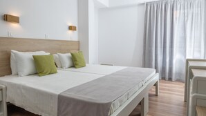 A modern hotel room with a large bed, two bedside tables, a wooden headboard, and a large window with curtains. - Santa Marina Unique Hotel (Agios Nikolaos)