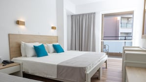 A hotel room with a large bed, bedside tables, a desk, and a view of the balcony. - Santa Marina Unique Hotel (Agios Nikolaos)