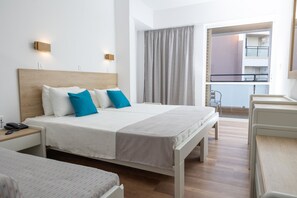 Hotellihuone, jossa on suuri sänky, yöpöydät, työpöytä ja näkymä parvekkeelle.