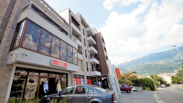 A multi-story building with a storefront labeled "D&D MODNI STUDIO". - Apartment IPEK (Budva)