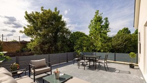 An outdoor patio with a sofa, chairs, and a table. - The Battersea Flat - Exquisite 2bdr Flat With Terrace (London)