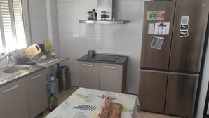 Una cocina compacta con un lavamanos, estufa y refrigerador.