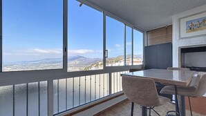 A balcony with a view of a cityscape and mountains.