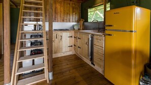 A kitchen with wooden cabinets, a yellow refrigerator, and a wooden ladder. - Awe Inspiring two Storey Tent (Battle)