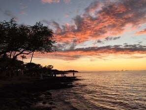A sunset view over a calm body of water with a tree and a small structure on the shore. - Kohala Estate Home 3 Bedroom Estate by RedAwning (Kamuela)
