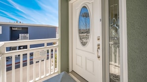 A white door with a glass panel and a balcony with a white railing. - 4 Bedroom Home Steps to the Sand in Newport Beach (Newport Beach)