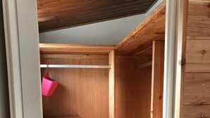 Un armario de madera con un cesto colgante y una puerta con cerradura.