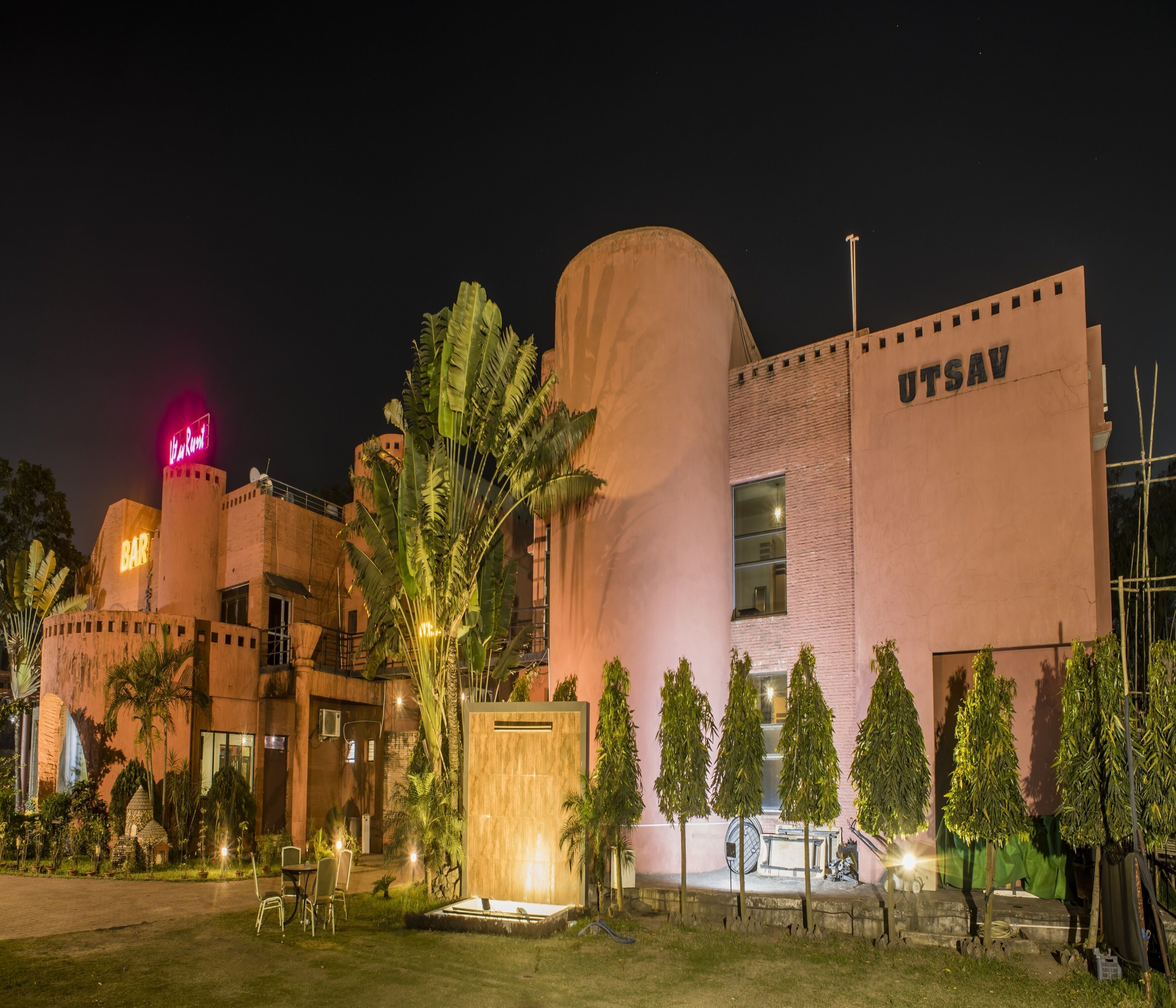 A building with a large sign reading "UTSAV" and a bar area with a neon sign.