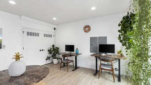 A modern living room with two wooden tables, a large potted plant, and a decorative pineapple on one table. - Chase's sweet suite - Micro Studio - 91Walkscore (Seattle)