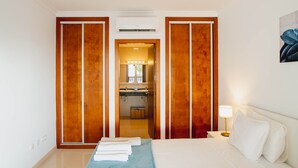 A hotel room with a bed, a nightstand, a lamp, and a bathroom visible through a door. - 6 Bed Holiday Villa | Heated Pool | Hot Tub | Beach & Waterparks | Playa Blanca (Playa Blanca)