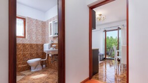 Ein Badezimmer mit Toilette, Waschbecken und Duschbereich.