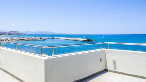 Un balcon avec vue sur la mer et un quai.