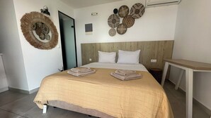 Une chambre d’hôtel avec un lit, un climatiseur fixé au mur et un élément décoratif rond sur le mur.