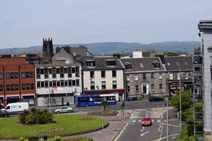 A street view with buildings, a bus, and cars.
