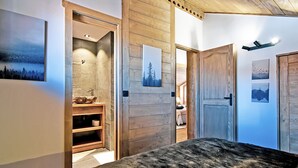 Un dormitorio con una cama grande, paredes de madera y un baño con tocador de madera.