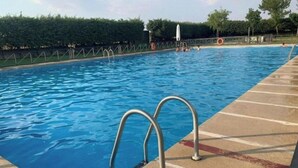 Piscina com guarda-corpos de metal e deck revestido com azulejos.