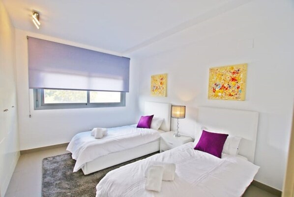 A hotel room with two beds, a window, a lamp, and two abstract paintings on the wall. - STYLISH 4 BED APT (MAX 6) POOL NR CABOPINO, MARBELLA (MARBELLA)
