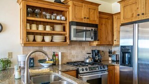 A kitchen with wooden cabinets, a stainless steel refrigerator, a microwave, a stove, and a sink. - Great Rates, Hot Tub, Tranquil Views & Location (Park City)