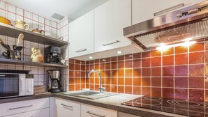 A modern kitchen with white cabinets, a stainless steel range hood, a microwave, and a digital oven display. - Charming 3-room with mezzanine for 6 pers, south balcony and parking in La Clusaz (La Clusaz)