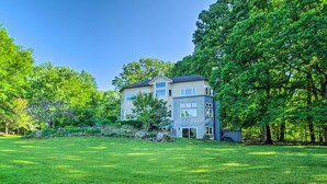 A multi-story residential building with a modern design, surrounded by lush greenery and a well-maintained lawn.