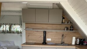 A compact kitchen with a wooden countertop, a sink, and a coffee machine. - Reed hut / pile dwelling on Lake Neusiedl (Ruster Bucht)