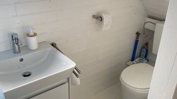 Een douche, handdoeken, zeep, toiletpapier