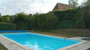 Una piscina rettangolare con interno blu, circondata da un solarium in pietra.